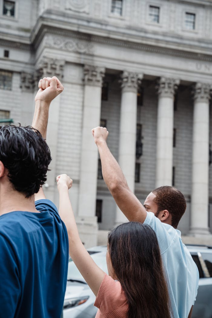 Acasa Protesters demonstrating with raised fists in front of a historical building, symbolizing unity and activism.